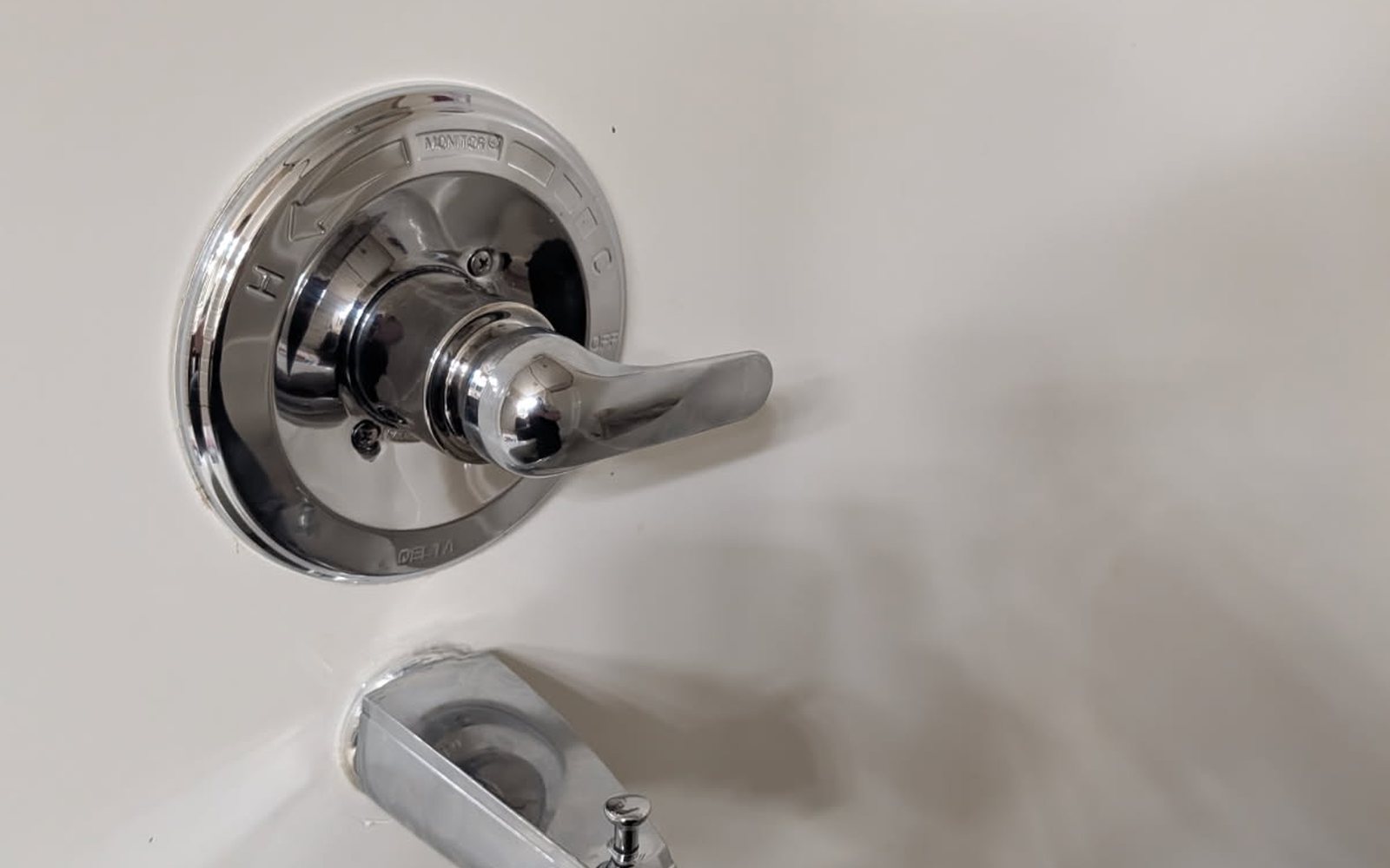 A plumber repairing a kitchen fixture in an Edmonton home